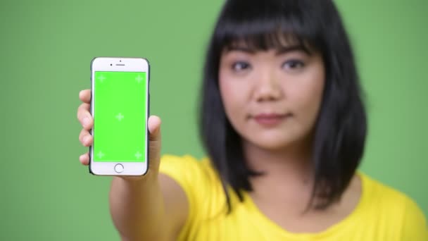 Hermosa mujer asiática feliz mostrando teléfono — Vídeo de stock