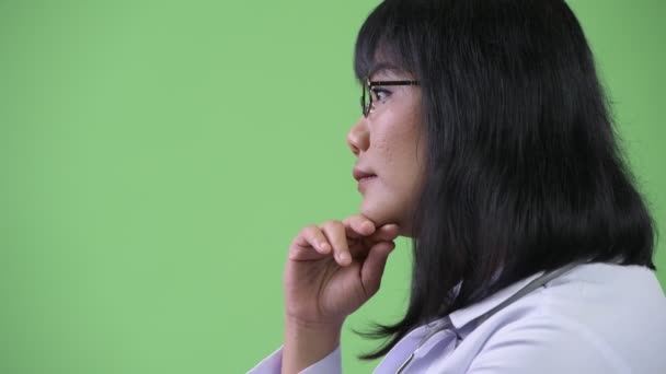 Profilo vista di bella felice donna asiatica medico pensando — Video Stock