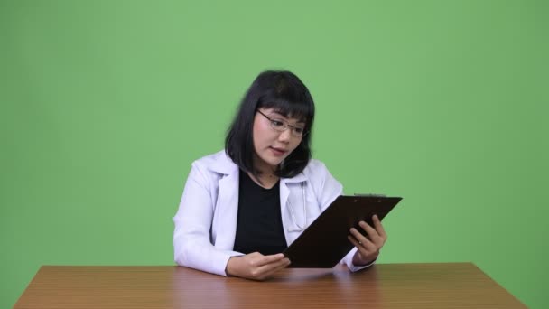 Krásná asijská žena doktor mluví podržíte schránky — Stock video