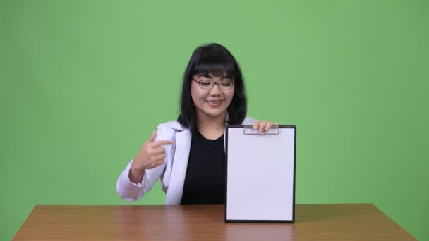 Schön asiatische Frau Arzt zeigt Klemmbrett und geben Daumen nach oben — Stockvideo