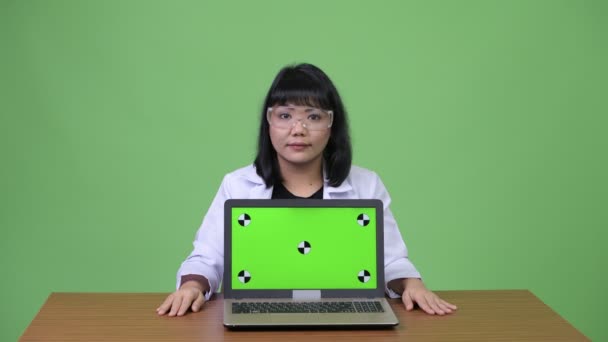 美しいアジアの女性医師のラップトップを示す保護メガネを着用 — ストック動画