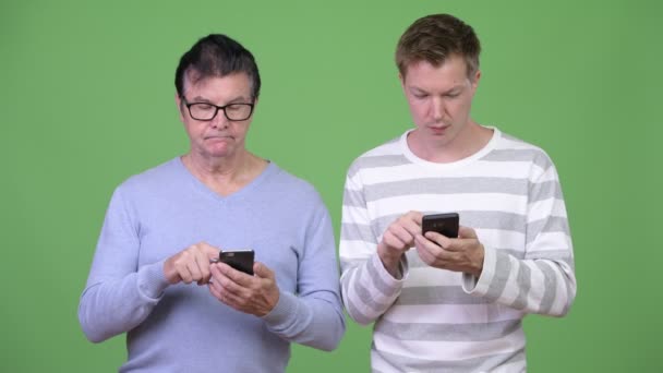 Senior bel homme et jeune bel homme utilisant le téléphone ensemble — Video