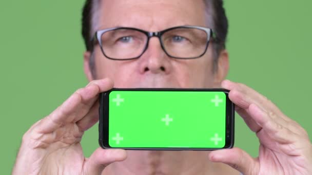 Senior schöner Mann zeigt Telefon und Denken — Stockvideo