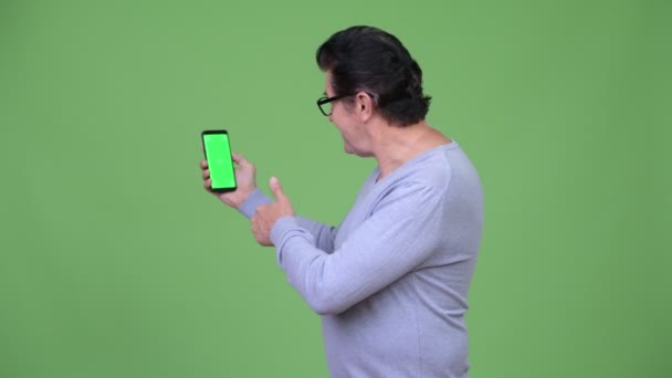 Senior knappe man met behulp van telefoon en geven duimen omhoog — Stockvideo