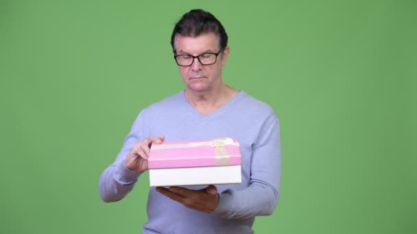 Hombre guapo mayor sosteniendo caja de regalo — Vídeos de Stock