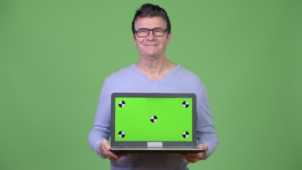 Старший красивий чоловік показує ноутбук — стокове відео