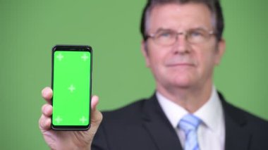 Üst düzey yakışıklı işadamı gösteren telefon