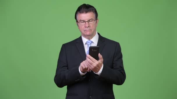 Senior hombre de negocios guapo usando el teléfono — Vídeos de Stock