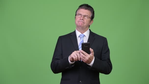 Senior przystojny biznesmen myślenia przy użyciu telefonu — Wideo stockowe