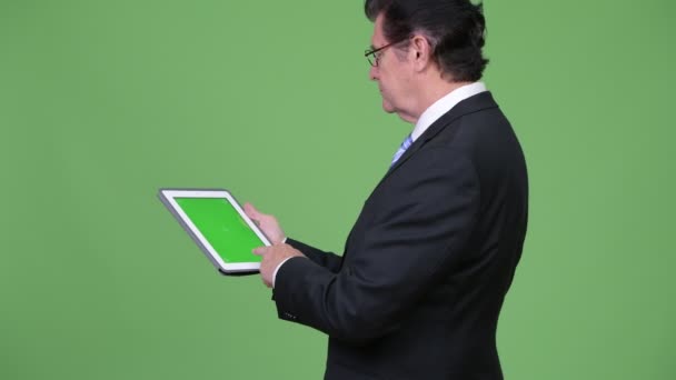 Senior hombre de negocios guapo utilizando tableta digital — Vídeo de stock