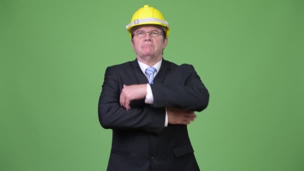 Senior handsome businessman as engineer with arms crossed — Stock Video