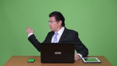 Chroma anahtar yeşil arka plana sahip karşı üst düzey yakışıklı adam stüdyo çekim