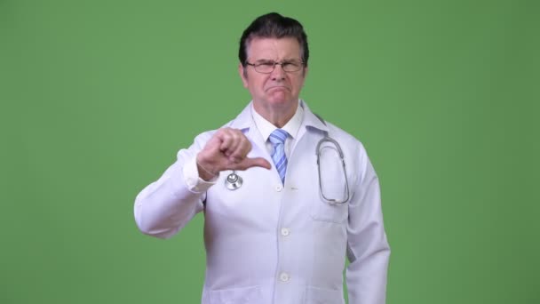 Старший красивий чоловік лікар дає великі пальці вниз — стокове відео