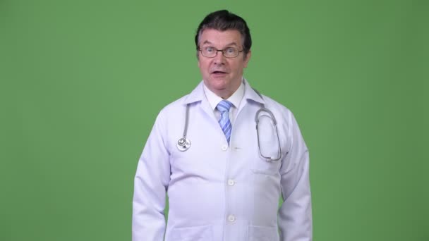 Äldre stilig man läkare med finger på läppar — Stockvideo