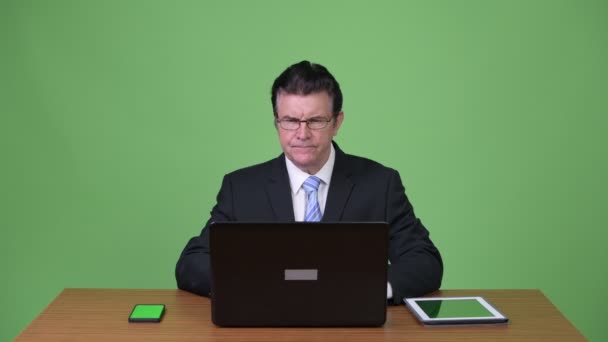 Senior gutaussehender Geschäftsmann Multitasking bei der Arbeit — Stockvideo