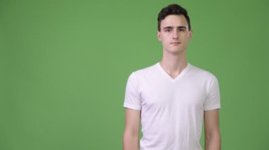 Genç yakışıklı bir adam bir şey gösteriyor.