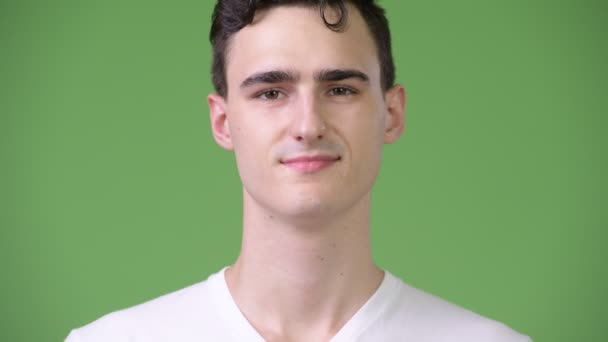 Fiatal jóképű férfi zöld háttér — Stock videók