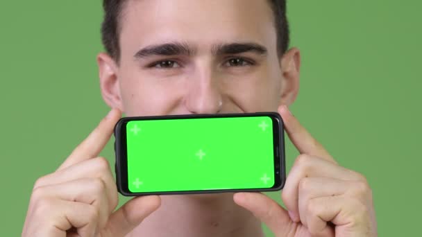 Joven hombre guapo mostrando el teléfono — Vídeo de stock