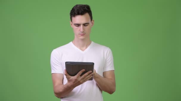 Jovem homem bonito usando tablet digital — Vídeo de Stock