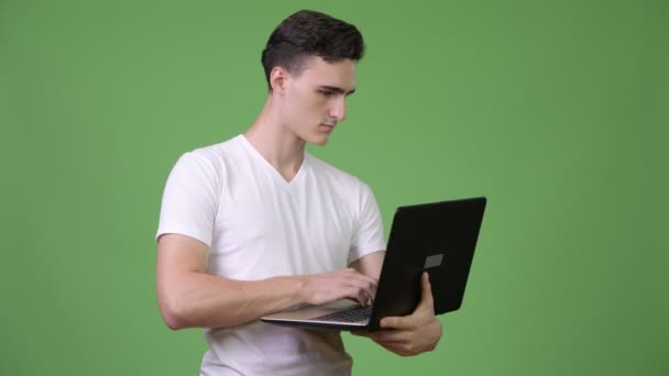 Dizüstü bilgisayar kullanan genç yakışıklı adam — Stok video