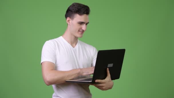 Knappe jongeman met behulp van laptop — Stockvideo