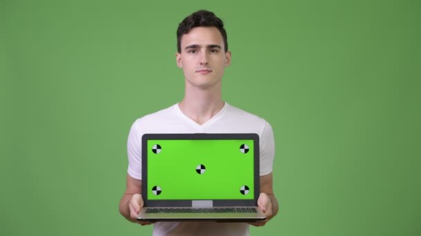 Молодой красивый мужчина показывает ноутбук — стоковое видео