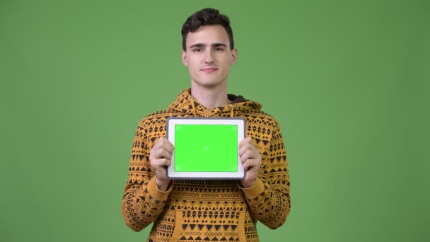 Joven hombre guapo mostrando tableta digital — Vídeos de Stock