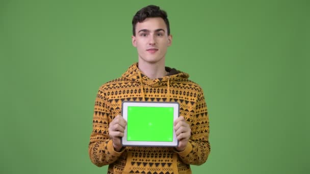 Giovane bell'uomo mostrando tablet digitale e guardando sorpreso — Video Stock