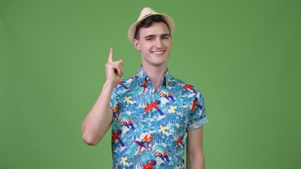 Joven turista guapo apuntando con el dedo hacia arriba — Vídeo de stock