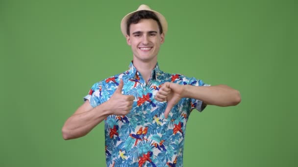 Jovem turista bonito homem escolher entre polegares para cima e polegares para baixo — Vídeo de Stock