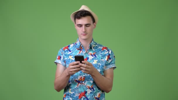 Jonge knappe toeristische man denken tijdens het gebruik van de telefoon — Stockvideo