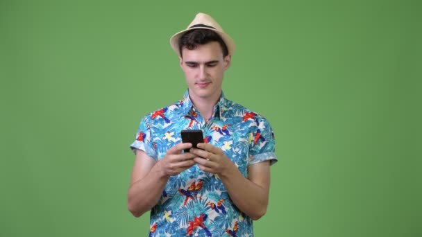 Joven guapo turista pensando mientras usa el teléfono — Vídeo de stock