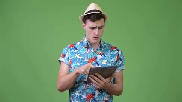 Young handsome tourist man using digital tablet and getting bad news — Stock Video