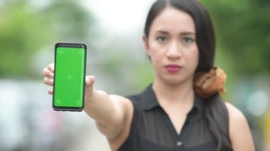 Genç mutlu güzel Asya iş kadını gösteren telefon sokakları havada