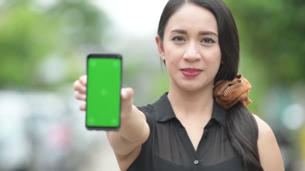 Jovem feliz bela mulher de negócios asiática mostrando telefone nas ruas ao ar livre — Vídeo de Stock