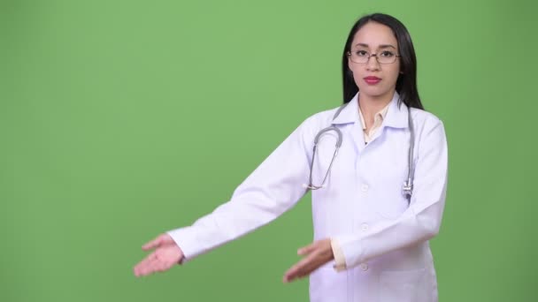 Jovem bela mulher asiática médico mostrando algo — Vídeo de Stock