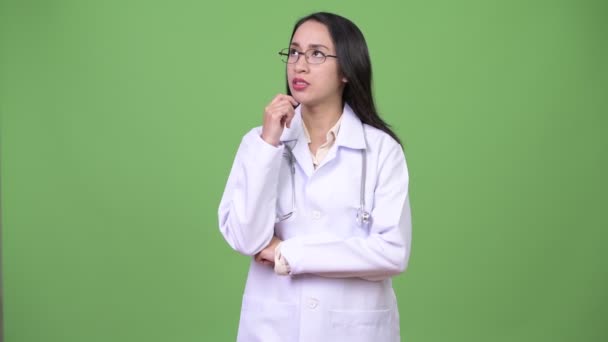 Νεαρή όμορφη ασιατική γυναίκα γιατρός σκέφτεται — Αρχείο Βίντεο