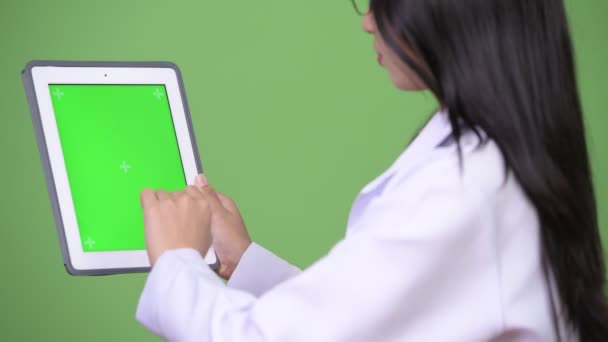 Giovane bella donna asiatica medico mostrando tablet digitale — Video Stock