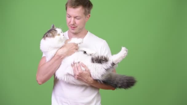 Jovem homem bonito feliz segurando gato persa — Vídeo de Stock