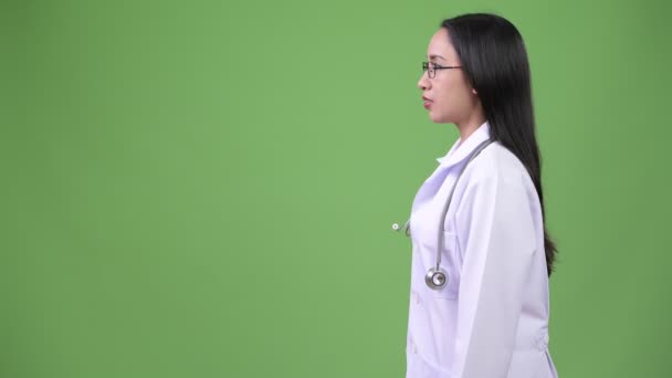 Профиль вид молодой красивой азиатской женщины врач улыбается — стоковое видео
