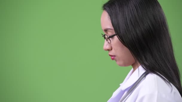 Profile view of young beautiful Asian woman doctor — Stock Video