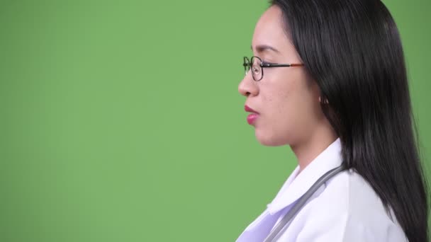 Perfil vista de joven hermosa mujer asiática médico pensando — Vídeo de stock