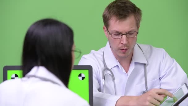 Ung asiatisk kvinna läkare ha möte med ung man läkare — Stockvideo