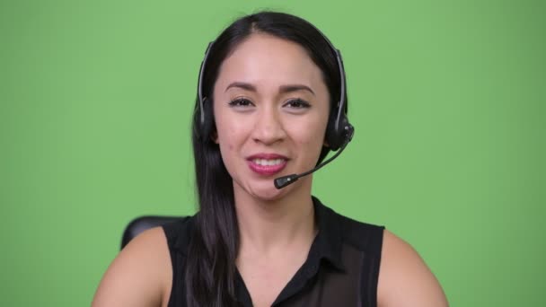 Jonge mooie Aziatische zakenvrouw als call center vertegenwoordiger — Stockvideo