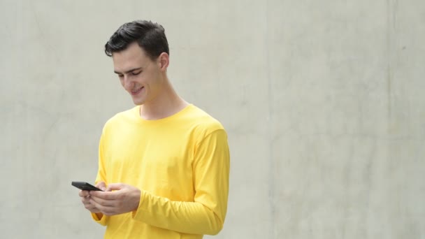 Joven hombre guapo feliz usando el teléfono — Vídeo de stock