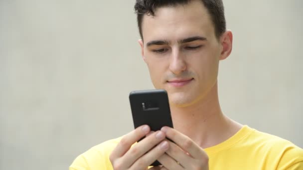 Joven hombre guapo feliz usando el teléfono — Vídeo de stock