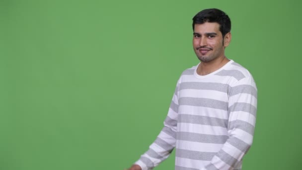 Junger hübscher persischer Mann zeigt etwas — Stockvideo