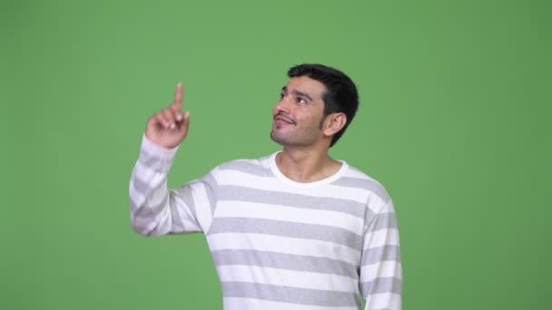 Joven hombre persa guapo señalando hacia arriba — Vídeos de Stock