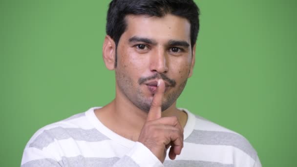 Молодой красивый персидский мужчина с пальцем на губах — стоковое видео