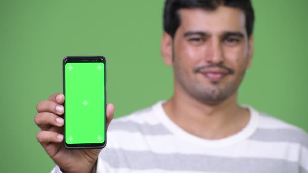 Joven hombre persa guapo mostrando el teléfono — Vídeos de Stock